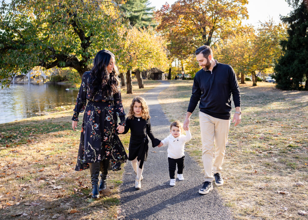 Family walking in Taylor Park in Essex County, surrounded by fall leaves