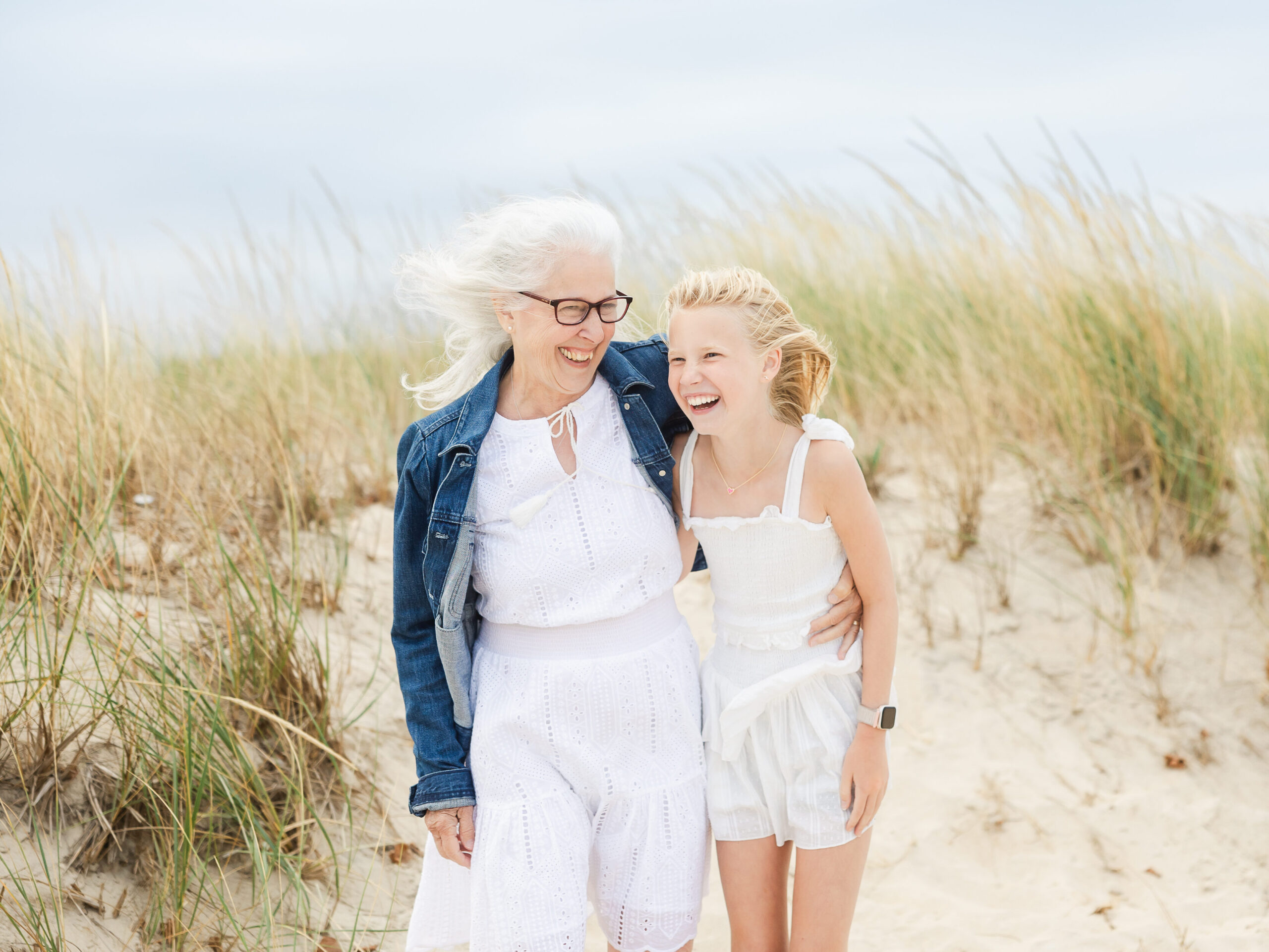 Laughing grandparent on a Jersey shore beach with her granddaughter
